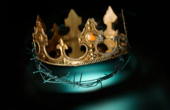 Antique gold crown with fleur-de-lis points and studded detail, set on a dark teal glowing orb with sharp metal spikes.