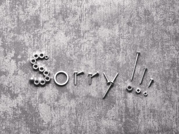 The word "Sorry!!" is creatively spelled out with various metal nuts and bolts on a gray textured background.